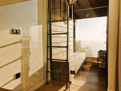 a glass room with a spiral ladder in front of a window at SHELL LIVING - Infinity Loft in Funchal