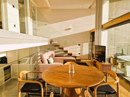 a living room with a table and chairs and a tv at SHELL LIVING - Infinity Loft in Funchal