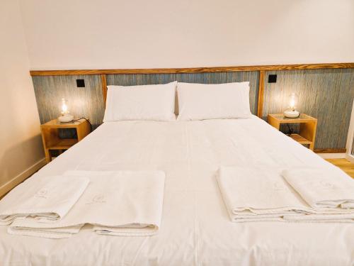 a bed with white sheets and towels on it at SHELL LIVING - Infinity Loft in Funchal