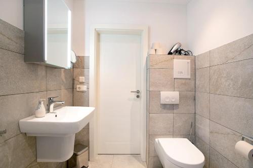 a white bathroom with a sink and a toilet at Lüttdeel in Gelting