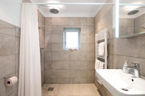 a white bathroom with a sink and a shower at Lüttdeel in Gelting