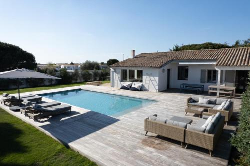 une cour arrière avec une piscine et une maison dans l'établissement Villa Madame - Pool - Near Beach and Golf, aux Portes