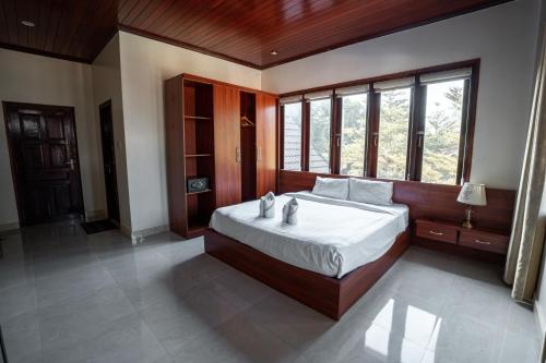 a bedroom with a large bed and a large window at Garden Resort in Vang Vieng