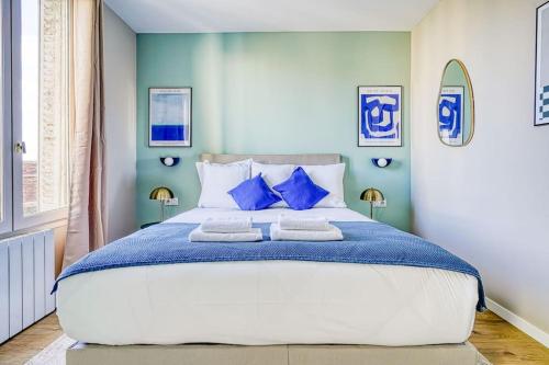 une chambre avec un grand lit aux murs bleus dans l'établissement Appartement Proche Porte de Choisy, à Ivry-sur-Seine