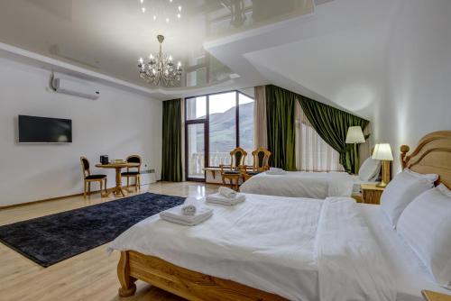Mountain View Hot Spring Resort في Alamedin: غرفة نوم بسريرين وطاولة وكراسي