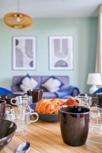 - une table avec un plateau de croissants et des tasses dans l'établissement Appartement Proche Porte de Choisy, à Ivry-sur-Seine