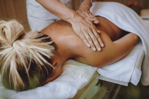 a woman getting a massage from a therapist at Superior Sport und Familienresort Alpenblick in Zell am See