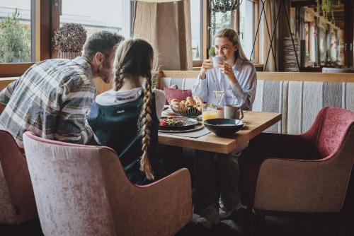 a group of people sitting at a table in a restaurant at Superior Sport und Familienresort Alpenblick in Zell am See