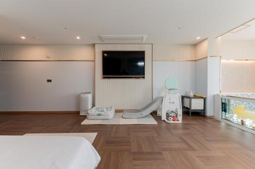 a bedroom with a bed and a slide and a tv at Yeongdo Grandbern Hotel in Busan