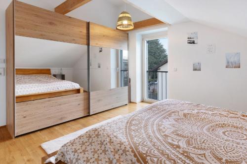 a bedroom with a large bed and a large window at Traum mit Seeblick in Allensbach