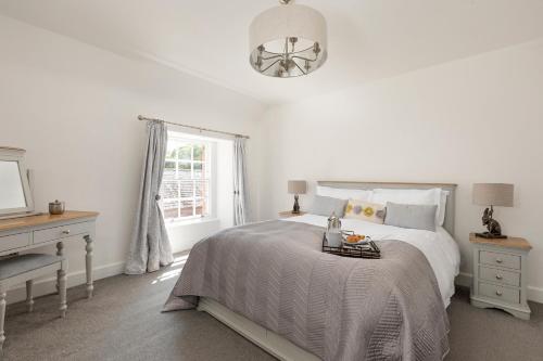 a white bedroom with a bed and a window at Stableyard Apartment: Drumlanrig Castle in Thornhill