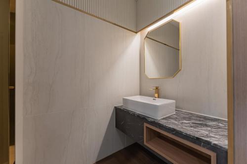 a bathroom with a sink and a mirror at Yeongdo Grandbern Hotel in Busan