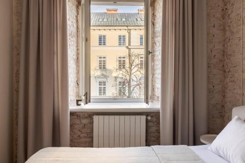 a bedroom with a window with a view of a building at InshiApartments on Rynok Square in Lviv