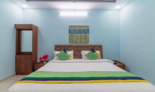 a bedroom with a large white bed with colorful pillows at Itsy Hotels Kurinji Stay Inn in Yelagiri