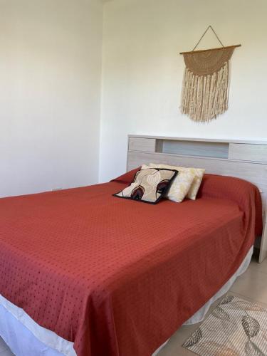 1 dormitorio con 1 cama roja y 2 almohadas en Tres Reinas en Carmen de Patagones