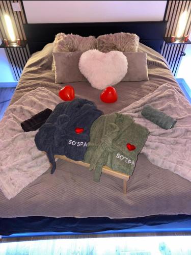 ein Bett mit zwei Handtüchern und Herz drauf in der Unterkunft So'Spa appart' jacuzzi & bien-être in Lingolsheim
