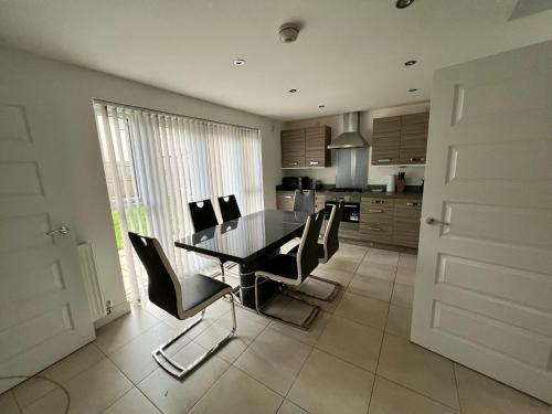 uma cozinha com uma mesa de jantar e cadeiras em Beautiful 4-Bedroom House with Private Garden & Parking em Edimburgo
