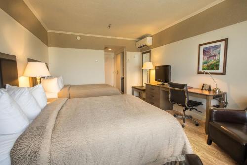 Postel nebo postele na pokoji v ubytování Hôtel le Manoir Baie-Comeau
