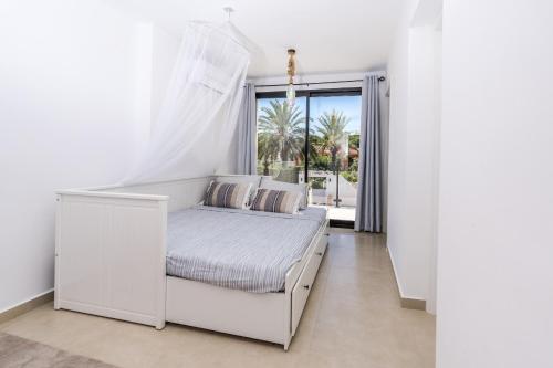 - un lit blanc dans une chambre avec fenêtre dans l'établissement Casa Pelefi, à Jávea