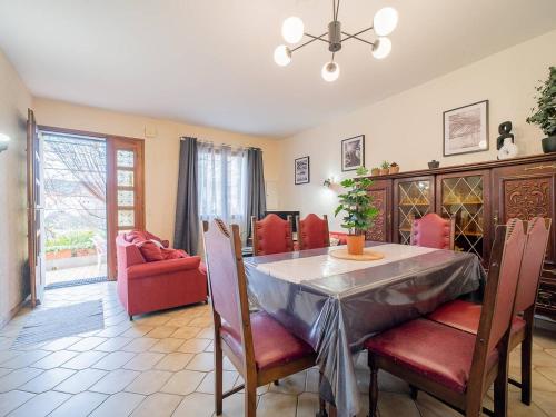une salle à manger avec une table et des chaises rouges dans l'établissement Maison F3 à Céret avec jardin, terrasses et climatisation, proche centre-ville - FR-1-703-96, à Céret