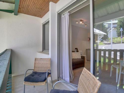 a room with two chairs and a balcony at Appartement confortable 4 pers avec balcon et casier à skis à Gourette - FR-1-400-114 in Eaux-Bonnes