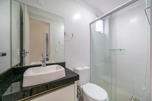 a bathroom with a sink and a toilet and a glass shower at Aluguel Apartamento 3 Quartos s 1 Suite Bombas in Bombas