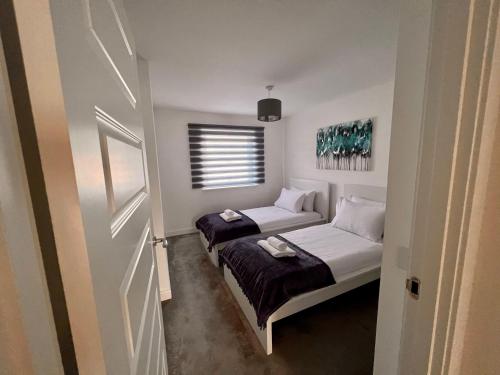 2 Betten in einem kleinen Zimmer mit Fenster in der Unterkunft Beautiful 4-Bedroom House with Private Garden & Parking in Edinburgh