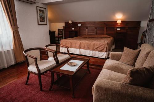 a hotel room with a bed and a couch and a table at Popova Kula Hotel & Winery in Demir Kapija