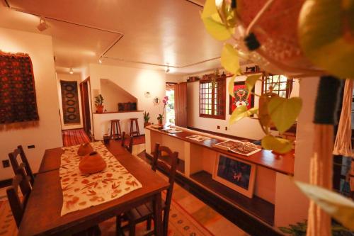 a living room with a table and a kitchen at Casa Örüm in Florianópolis