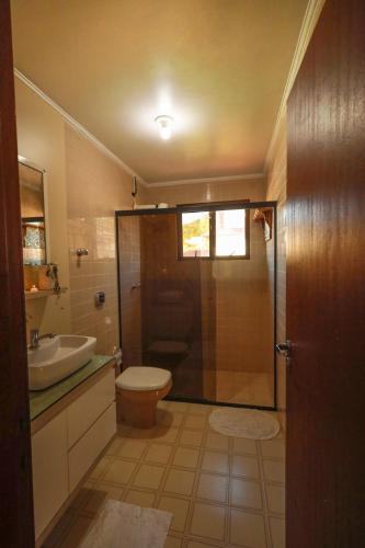 a bathroom with a shower and a toilet and a sink at Casa Örüm in Florianópolis