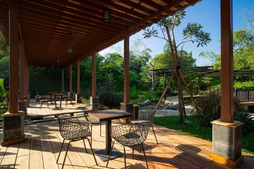 une terrasse en bois avec des tables et des chaises. dans l'établissement NIWA CANTING, à Brumbung
