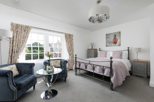 a bedroom with a bed and a couch and a table at Stableyard Studio: Drumlanrig Castle in Thornhill