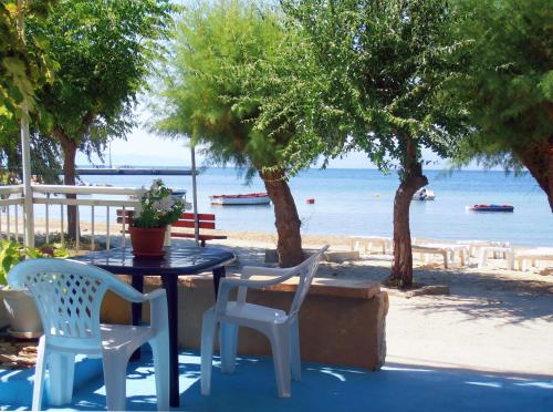 a table and chairs with a view of the beach at Malimi in Prinos
