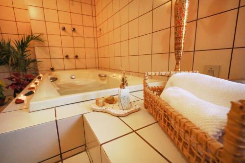 a bathroom with a tub and a basket of towels at Casa Örüm in Florianópolis