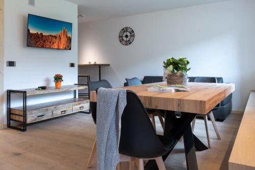 ein Esszimmer mit einem Holztisch und Stühlen in der Unterkunft Casa Paolina - Alpine Stay Apartments in Tesero