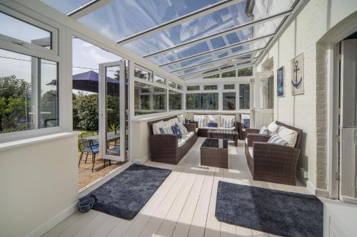 a conservatory with chairs and a couch and windows at Solenta in Yarmouth