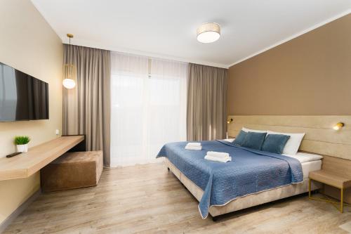 Habitación de hotel con cama y TV en Bel Mare Holiday Apartments near the Beach with PARKING by Renters, en Międzyzdroje