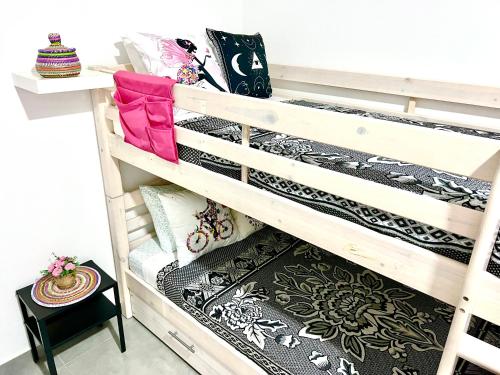 a stack of bunk beds in a room at Animos! Apartments - 10 modern apartments near the city & beach, perfect for nomads, travellers, families, watersports! in Santa Maria