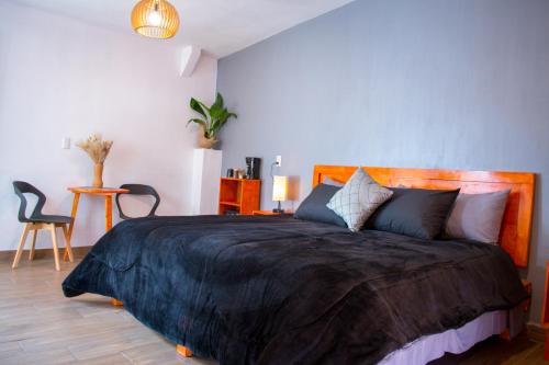 um quarto com uma cama grande e um cobertor preto em Piedra Negra Boutique Hotel em San Cristóbal de Las Casas