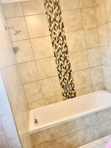 um chuveiro com uma banheira branca na casa de banho em Makarios em Pretoria