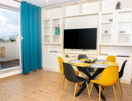 a dining room with a table and yellow chairs at Sunny House Apartment 44 Malta in Taʼ Xbiex