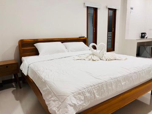 a bed with white sheets and white shoes on it at Sisters Home ที่พักใกล้สวนพฤกษศาสตร์ ระยองแหลมแม่พิมพ์ in Ban Ko Kok