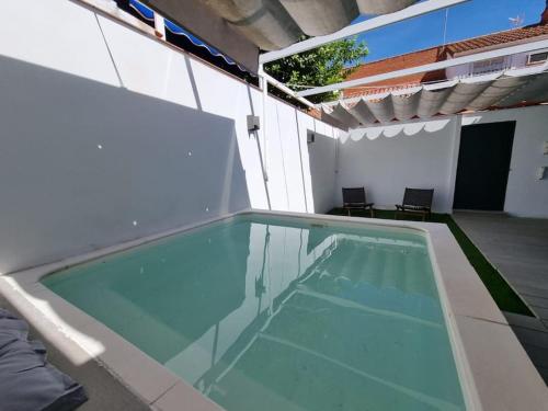 uma piscina no lado de uma casa em Casa Familiar en Sevilla Este em Sevilha