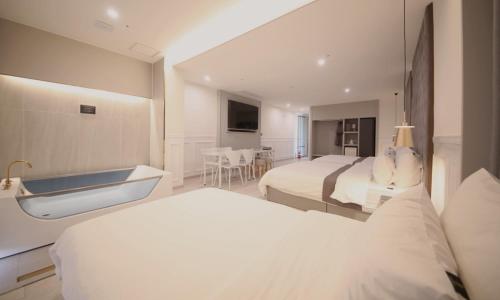 a hotel room with two beds and a sink at Yeongdo Grandbern Hotel in Busan