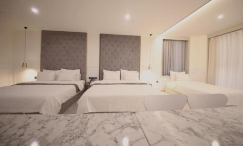 a hotel room with two beds and two windows at Yeongdo Grandbern Hotel in Busan