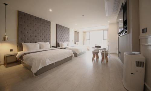 a large hotel room with two beds and a table at Yeongdo Grandbern Hotel in Busan