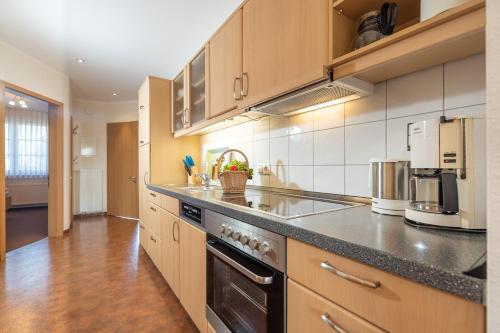 a large kitchen with wooden cabinets and appliances at Ferienwohnung Margaretha, App 18 in Ostseebad Sellin