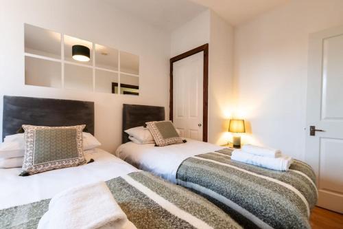 dos camas sentadas una al lado de la otra en un dormitorio en Prime Location 1-bedroom apartment - Close to Solent-Hospital-Amazon Voucher for long stay, en Southampton