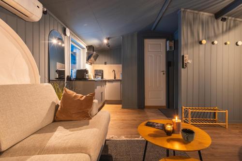 a living room with a couch and a table at Aera - Glass cabins in Tromsø