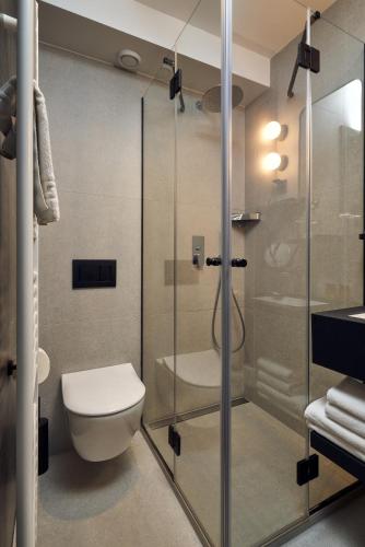 a bathroom with a toilet and a glass shower at The Hotel Ljubljana in Ljubljana